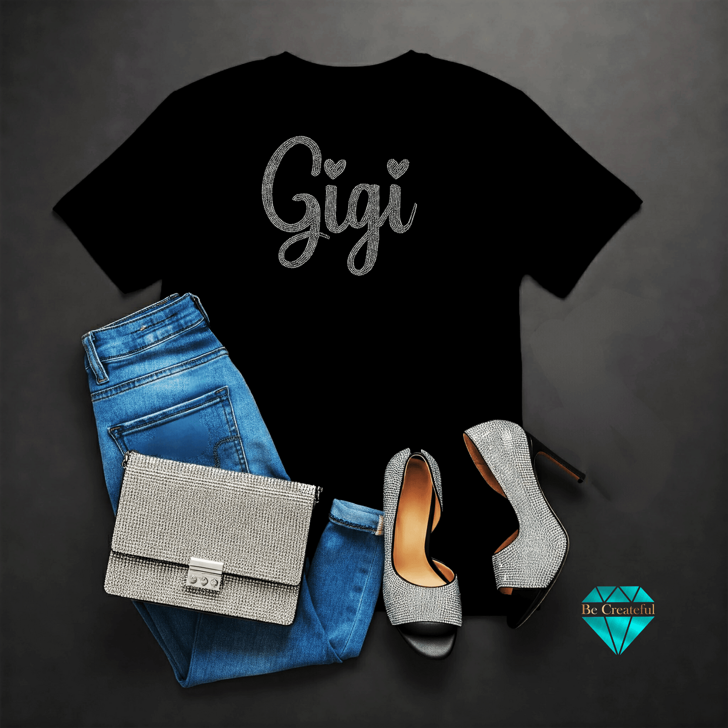 Black rhinestone t-shirt with 'Gigi' text, blue jeans, on a dark background.