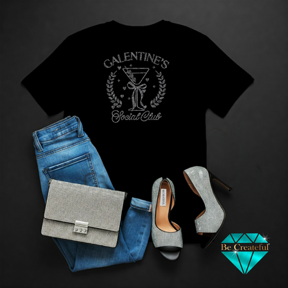 Black t-shirt with 'Galentine's Social Club' design, blue jeans, silver handbag, and high heels on a dark background.