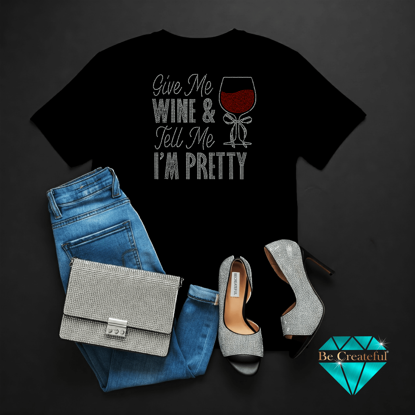 Black t-shirt with 'Give Me Wine & Tell Me I'm Pretty' text, blue jeans, and high heels on a dark background.